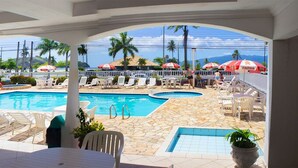 A poolside area with lounge chairs, a slide, and umbrellas.