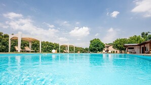 Una piscina con sillas de descanso y una pérgola.