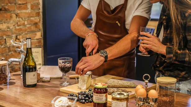 Un comptoir en bois sur lequel sont disposés divers produits alimentaires et une bouteille de vin.