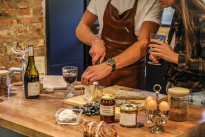 Un comptoir en bois sur lequel sont disposés divers produits alimentaires et une bouteille de vin.
