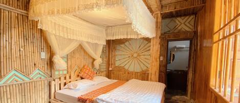 A room with a bed, a canopy, and a door.