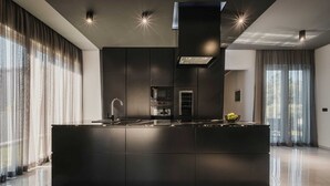 Une cuisine moderne dotée d’un îlot central, d’appareils électroménagers intégrés et d’un design épuré.