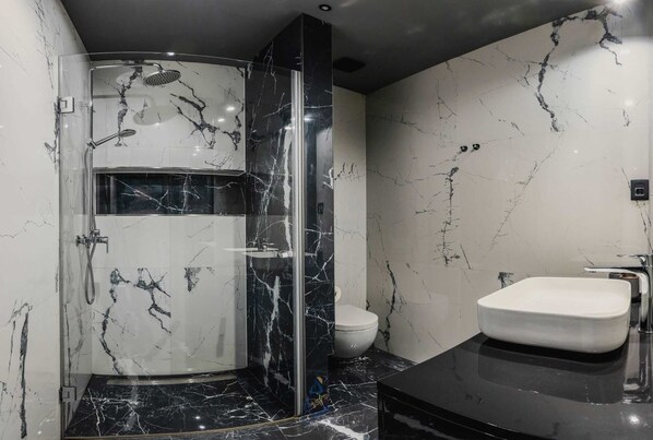 A modern bathroom with a glass-enclosed shower, a white toilet, and a black sink. - Modern 3-BR villa for 6 with pool, surrounded by pine forest near beach (Valica)