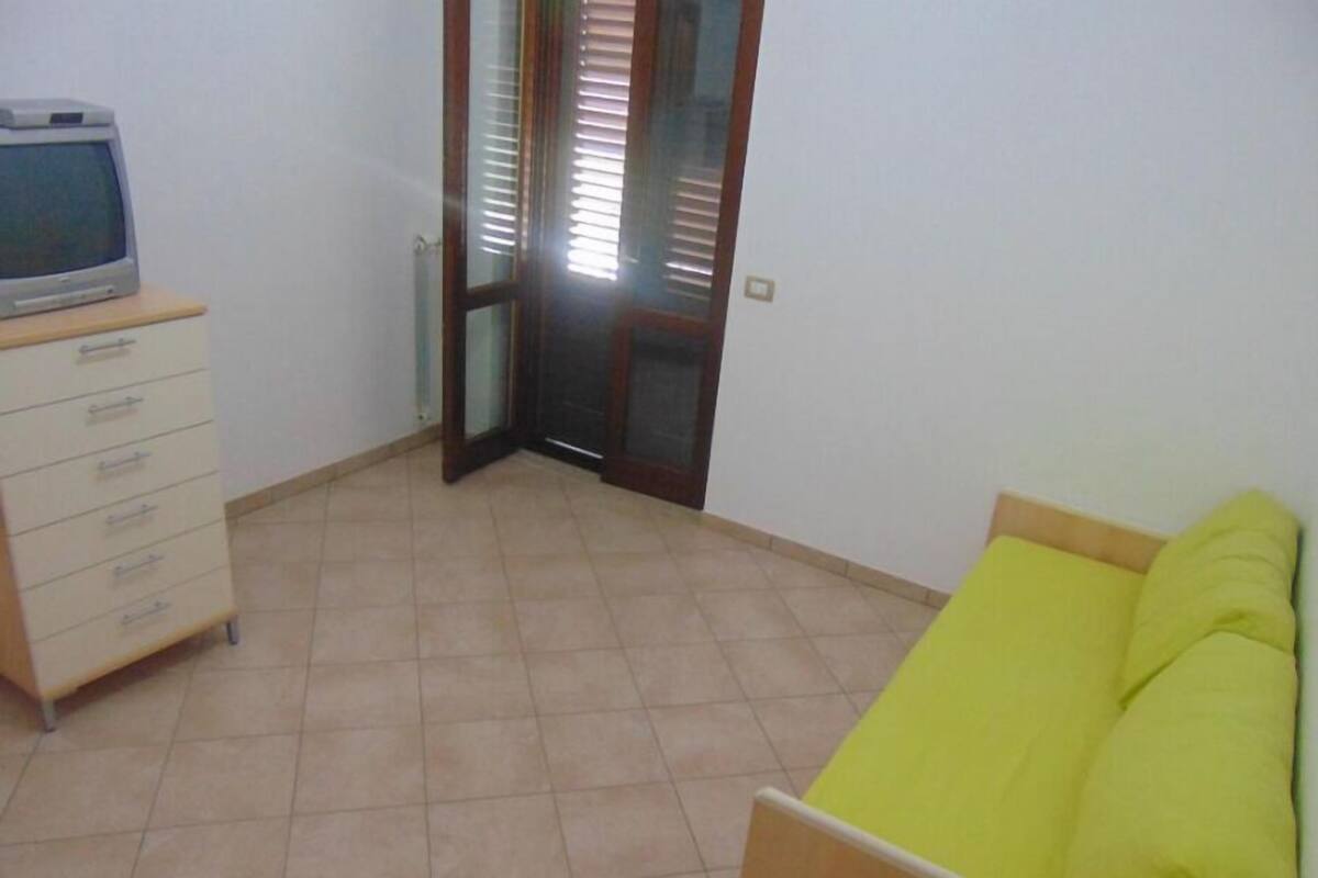 Ein Zimmer mit einem Bett, einem Schminktisch und einem Fernseher.