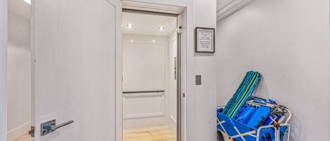 A hotel entrance with a 'WELCOME' sign, a luggage cart, and a framed notice on the wall.