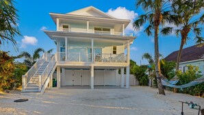 A two-story beachfront house with a balcony, a staircase, and a hammock. - Beachview Retreat: Steps to the beach, Gulf views! (Anna Maria)