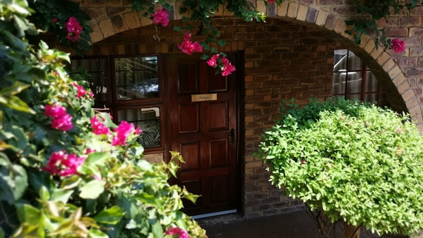 A brick building with a wooden door labeled "Kings" under an arched window. - Bastille de Blignaut B&B (Edenvale)