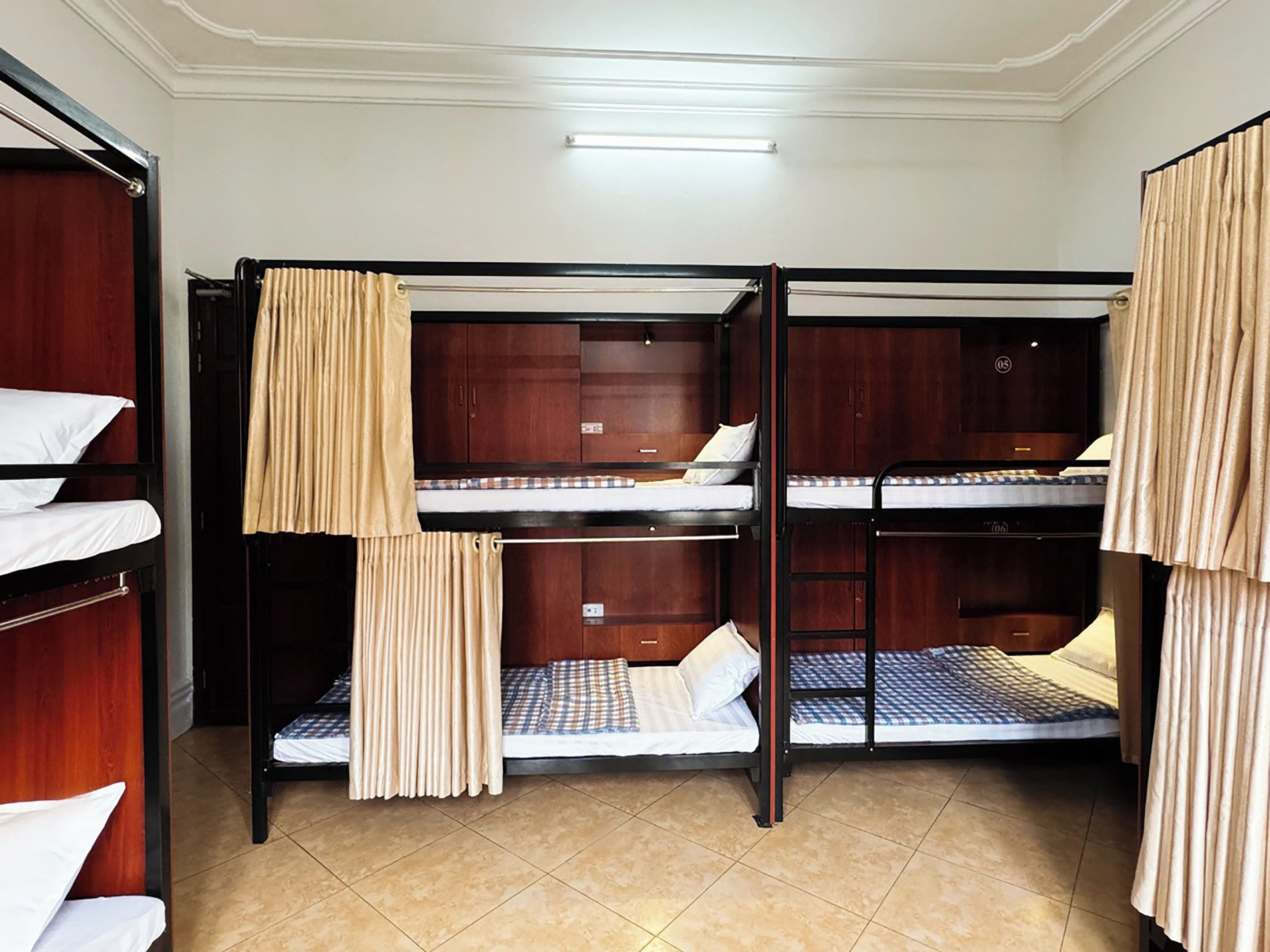 A room with bunk beds, wooden cabinets, and a tiled floor.
