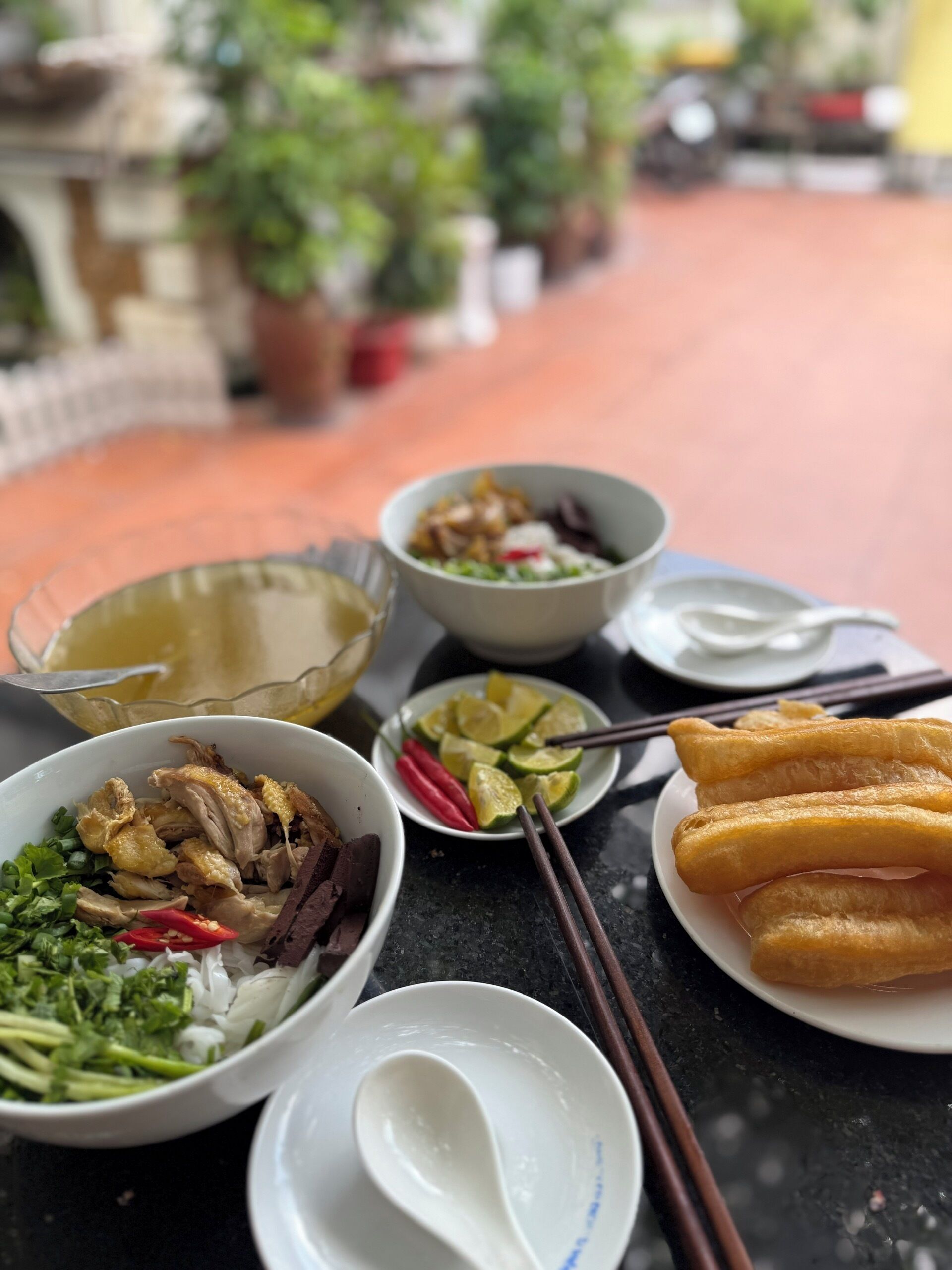 A table with various dishes including a bowl of sliced meat, a plate of fried items, and a bowl of vegetables.