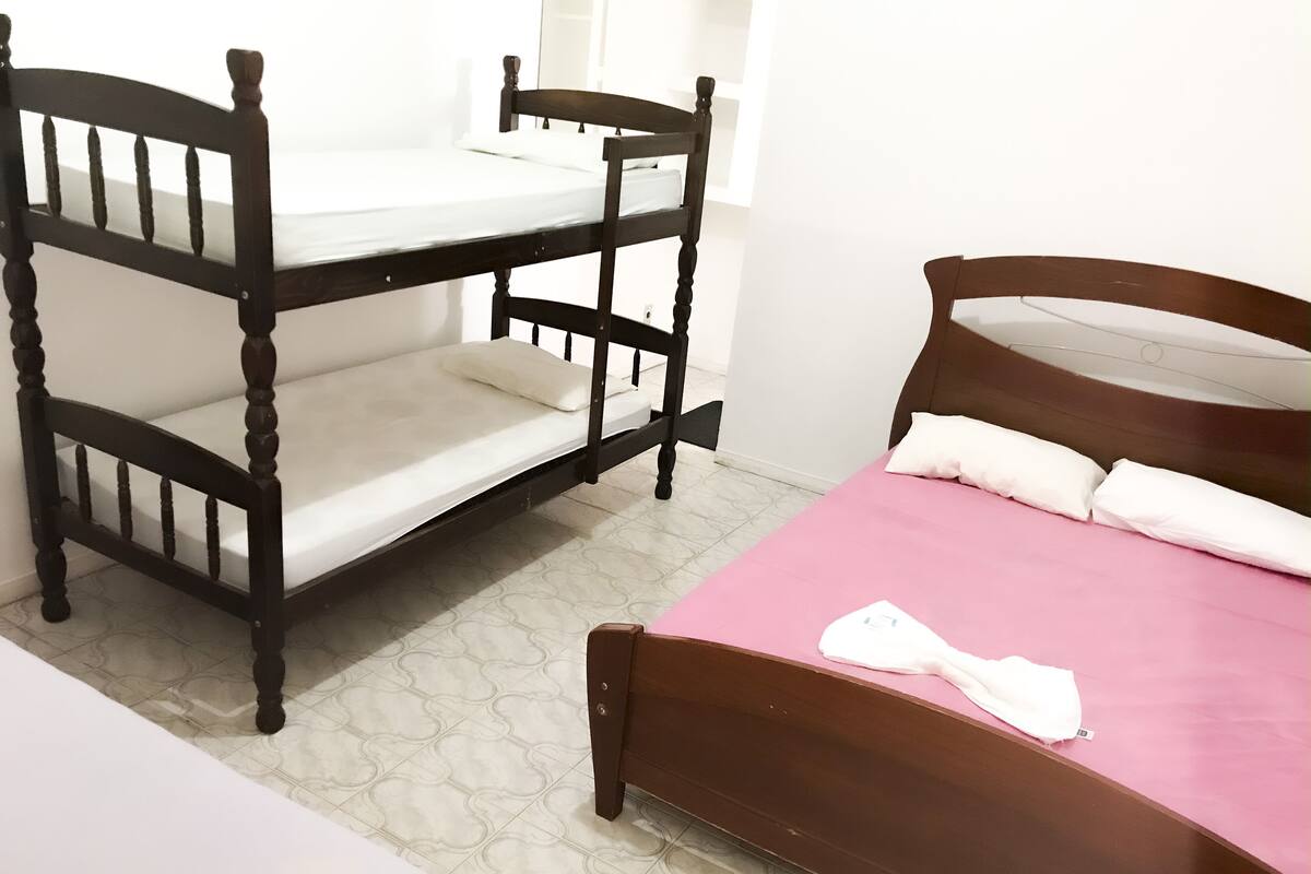 A room with a bunk bed and a single bed.