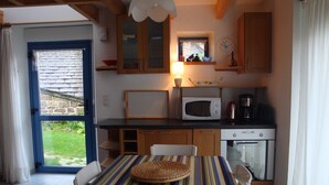 Une cuisine compacte équipée d’un four à micro-ondes, d’une machine à café et d’une petite fenêtre.