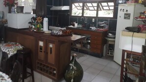 A kitchen with a central island, a refrigerator, and a sink. - SITE REFUGIO DO RIO - BANANAL - SP (BANANAL)