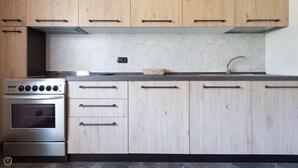 Una cocina moderna con armarios de madera, horno de acero inoxidable y un lavamanos.