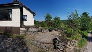 A modern house with a stone pathway leading to a wooden fence. - Strontian Boutique Bed & Breakfast (Acharacle)