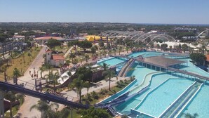 A large water park with multiple swimming pools, a bridge, and a castle-like structure. - ATTILA apartment by the sea (QUARTEIRA)