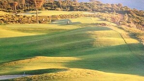 A golf course with rolling hills, a flagstick, and a water hazard. - ATTILA apartment by the sea (QUARTEIRA)
