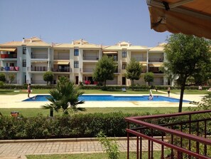 A hotel with multiple balconies, a swimming pool, and a well-maintained garden. - ATTILA apartment by the sea (QUARTEIRA)