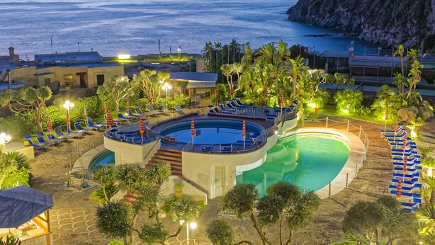 A resort with a pool, lounge chairs, and a view of the sea. - Hotel Zaro (Forio)