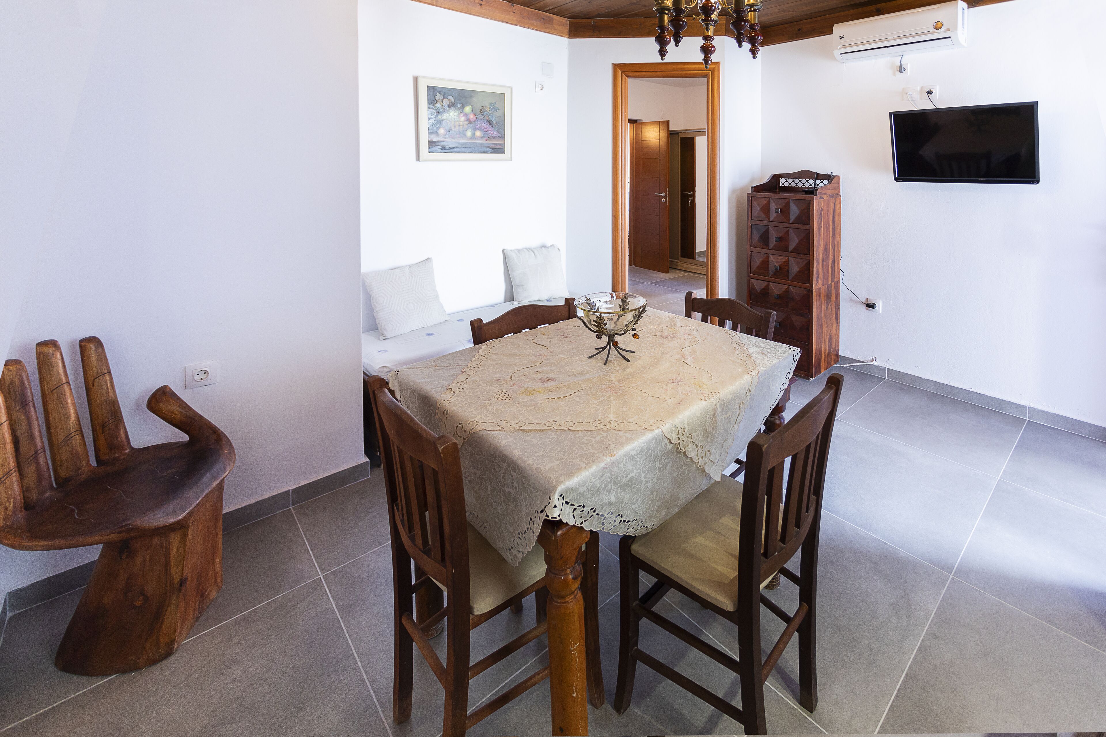 A dining area with a table set for six, surrounded by wooden chairs.