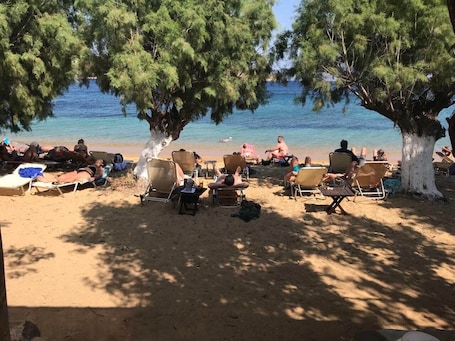 En la playa, sillas reclinables de playa, sombrillas, bar en la playa