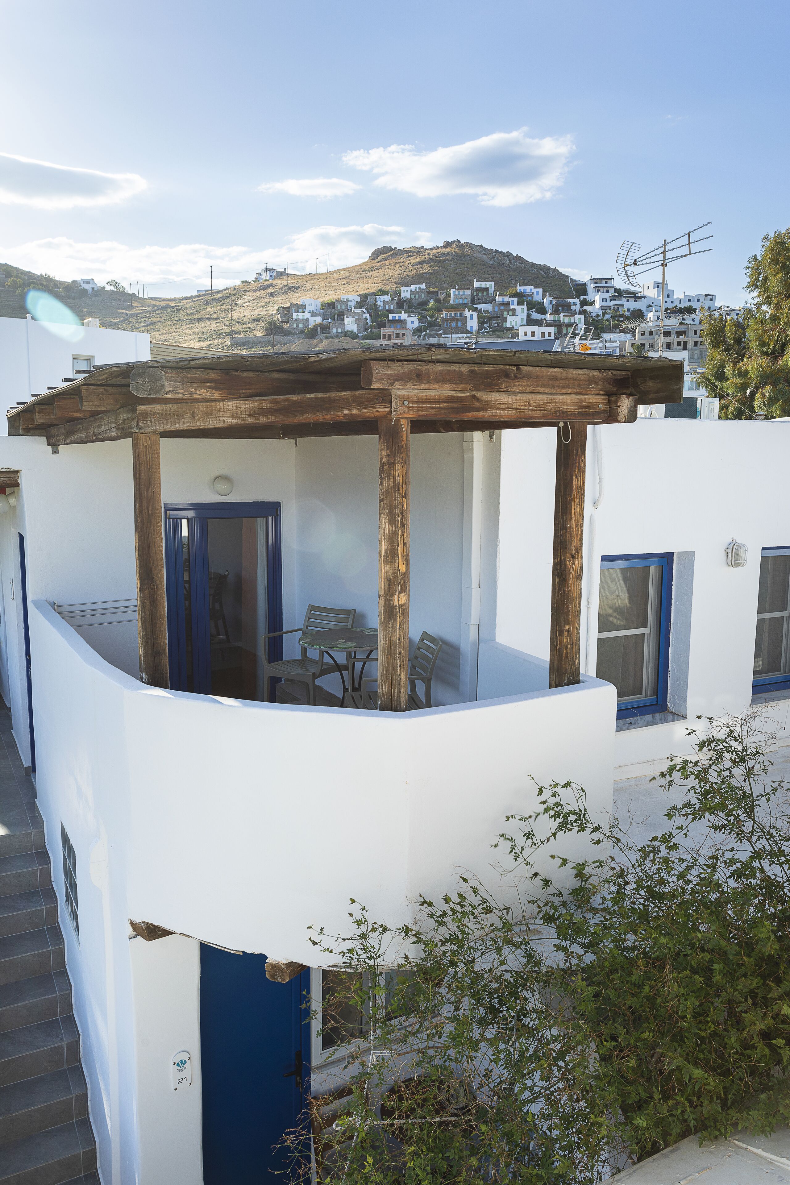 A white building with a wooden balcony and a table.