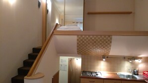 A kitchen with a gas stove, sink, and wooden cabinets. - Apartamenty Varsovie Zelazna (Warsaw)