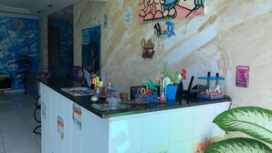 A reception desk with a clock, a Wi-Fi sign, and a colorful mural on the wall. - Casa Porto Hospedaria (Ipojuca)