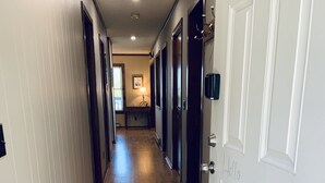 A hallway with wooden flooring, white walls, and a door labeled "3120".