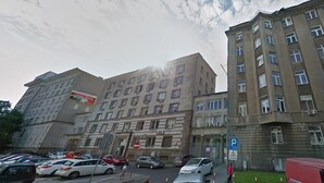 A multi-story building with a parking lot in front. - Apartamenty Varsovie Chmielna (Warsaw)