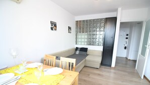 A compact living space with a dining area, a sofa bed, and a kitchen area. - Apartamenty Varsovie Chmielna (Warsaw)