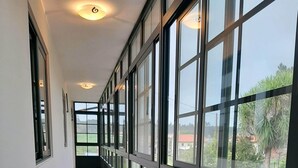 A corridor with large windows, tiled floor, and ceiling lights. - Casa Galipendre, in the heart of Galicia (A Estrada)