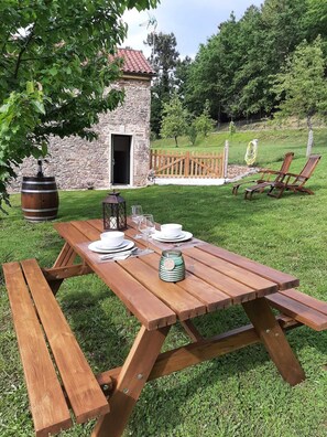A picnic table set up outdoors with a stone building in the background. - Casa Galipendre, in the heart of Galicia (A Estrada)