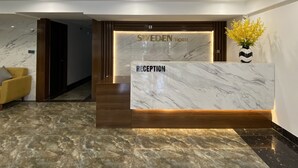 A reception desk with a marble top and a wooden base, labeled "SWEDEN HOTEL RECEPTION". - SWEDEN Hotel and Apartment (Da Nang)