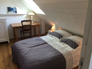 Un dormitorio con cama, escritorio y silla.