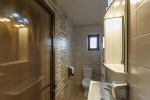 A modern bathroom with a toilet, sink, and a small window. - Dany Luxury Apartment (Pitesti)