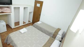 A hotel room with two beds, a TV, a wardrobe, and a washing machine.