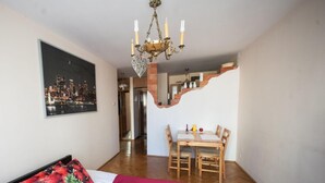 A bedroom with a bed, a dining table, and a staircase. - Apartamenty Varsovie Sliska (Warsaw)