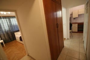 A room with a wooden wardrobe, a bed, and a small white table. - Apartamenty Varsovie Sliska (Warsaw)