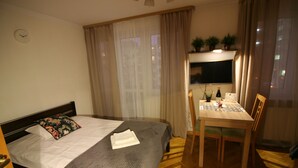 A hotel room with a bed, a desk, and a TV. - Apartamenty Varsovie Superb Panska 5 (Warsaw)