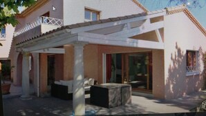 A modern villa with a spacious patio, large windows, and a flat roof. - Maison d'Architecte chez Huguette (Villalier)