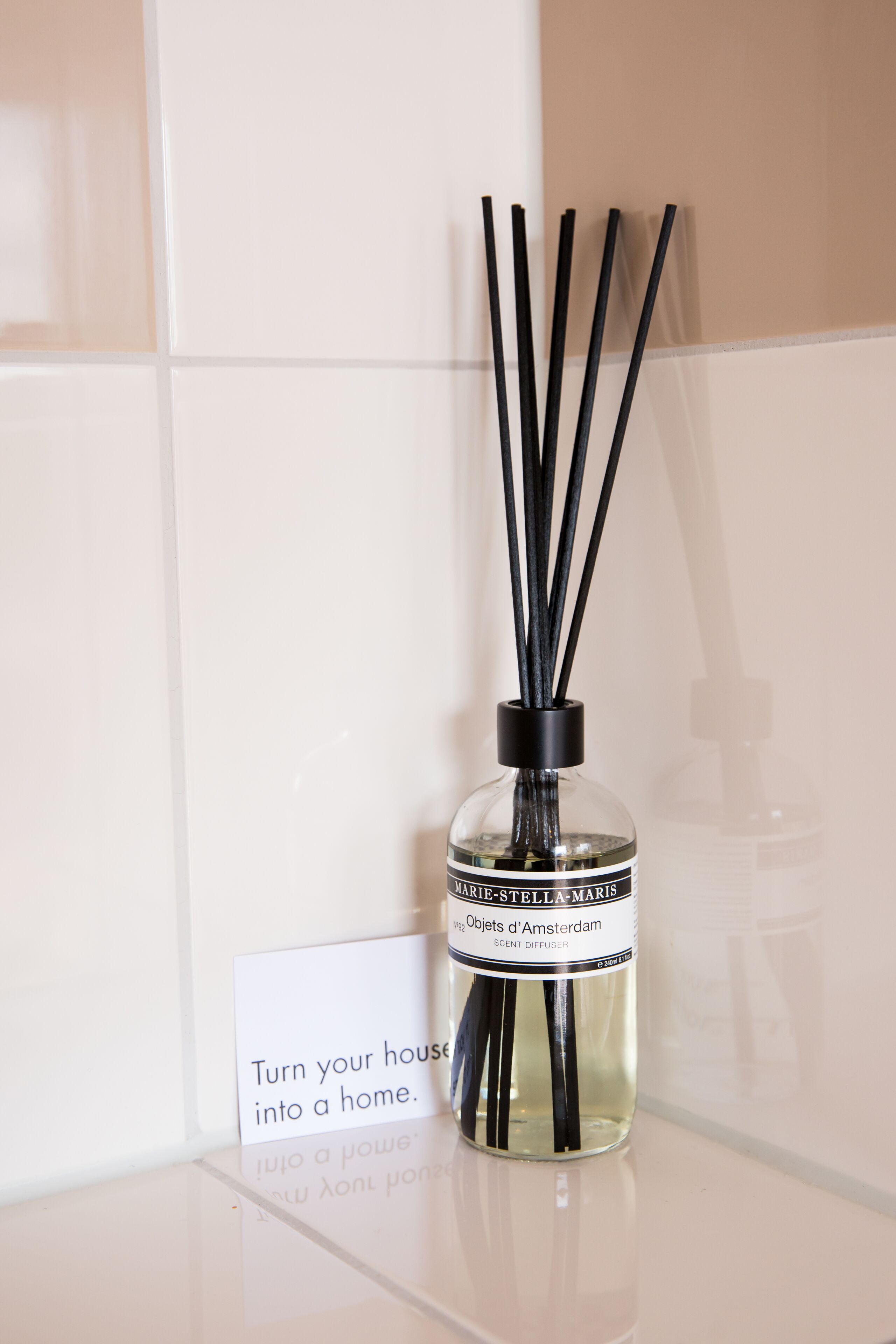 A clear glass bottle with black reeds and a label that reads "MARIE-STELLA MARIS Scent Diffuser."