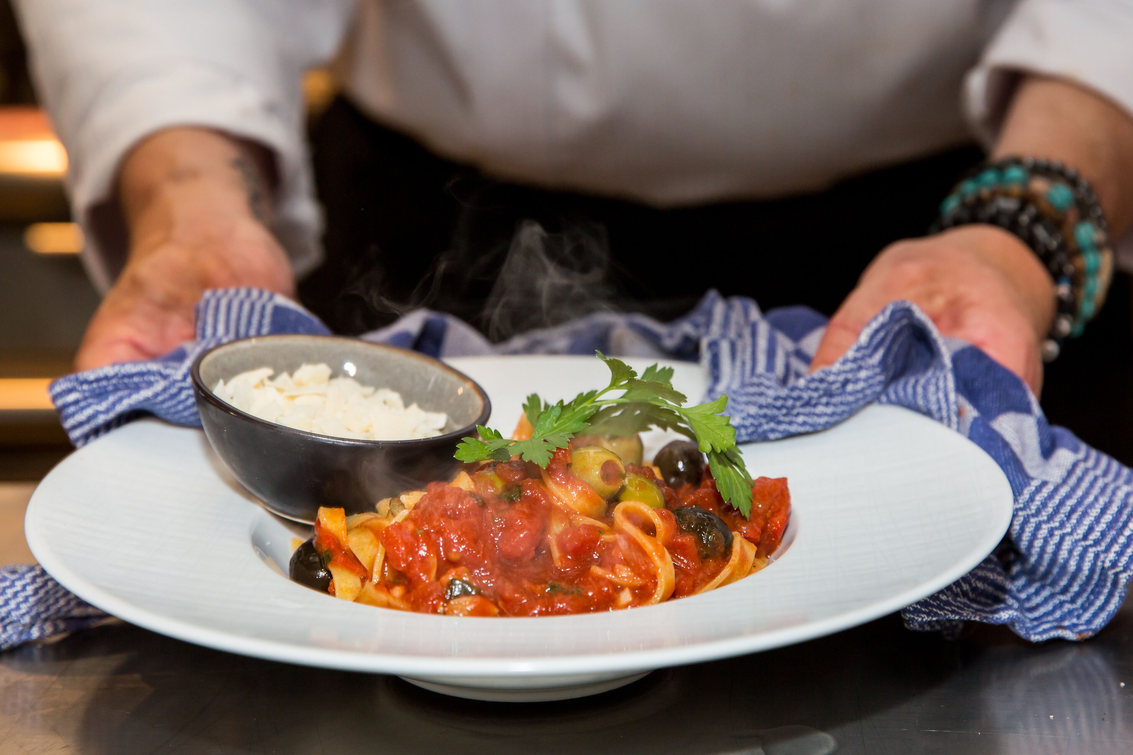 A plate of pasta with a side of rice and a garnish of parsley.