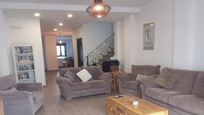 A modern living room with two sofas, a coffee table, and a bookshelf.