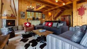 A cozy log cabin interior with a fireplace, wooden furniture, and a ski-themed decor. - Chalet Teremok - Jacuzzi & Sauna - Great for families (Riddes)