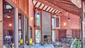 An outdoor patio area with wooden furniture and a fire pit. - Wooded LODGE, Sleeps 9, Pet Friendly, Accessible (Ben Wheeler)