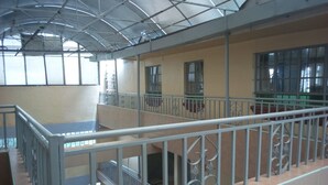 Ein mehrstöckiges Gebäude mit Metallgeländer, einer Treppe und einer Glaskuppel.