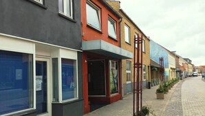 Una hilera de edificios modernos con grandes ventanales y un pavimento.
