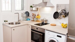A compact kitchen with a sink, stove, oven, and washing machine. - Cozy Studio Athens Downtown - Sleeps 3 (Athens)