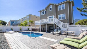 A residential backyard with a swimming pool, outdoor furniture, and a two-story house. - Oceanside, Private Pool, Hot Tub, 410 ft to Beach Access! CP8, Moore Fun, Less Work (Corolla)