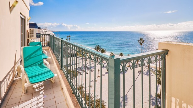 A balcony with a view of the sea, a green bench, and a railing. - Apartment Meerlust with fantastic sea view and large balcony and garage (Armacao de Pera)